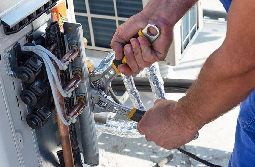 Technician tightening copper lines during boiler repair services in Wilmington, NC