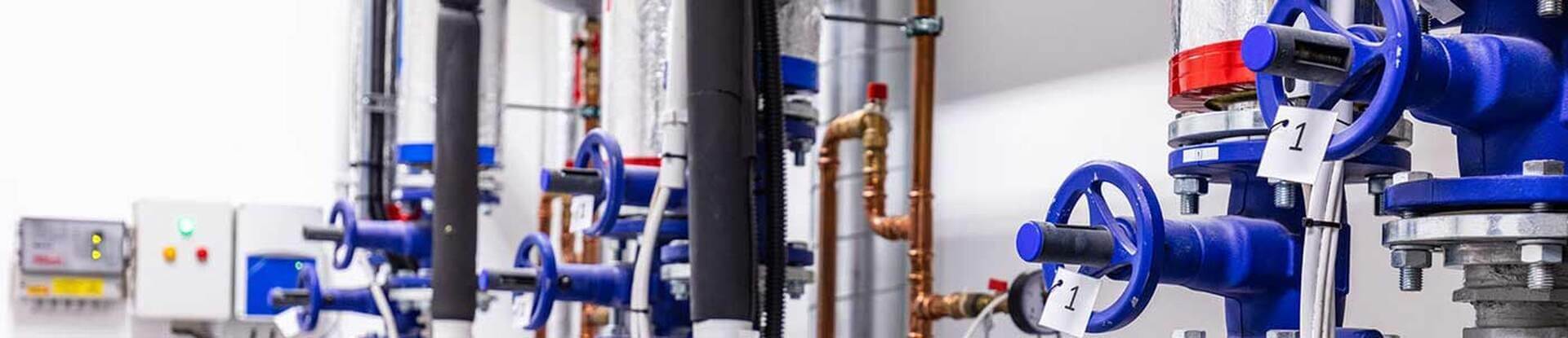 Blue valve manifolds and copper piping inside a commercial heating and air system in NC