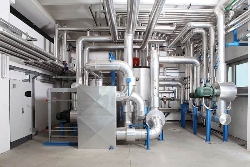 Complex ductwork and air handling units inside a commercial industrial HVAC system installation