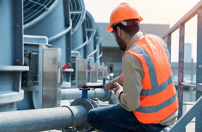 Technician adjusting rooftop valve for one of the leading commercial HVAC companies in North Carolina
